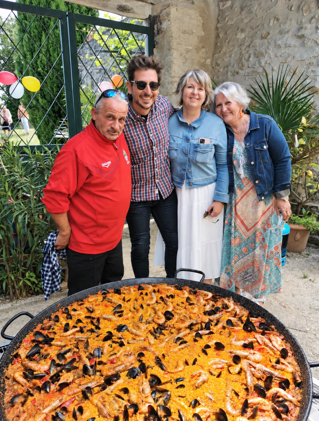 José Romera et les invités derrière la paella préparée dans la cour du Mas d'Eylieux