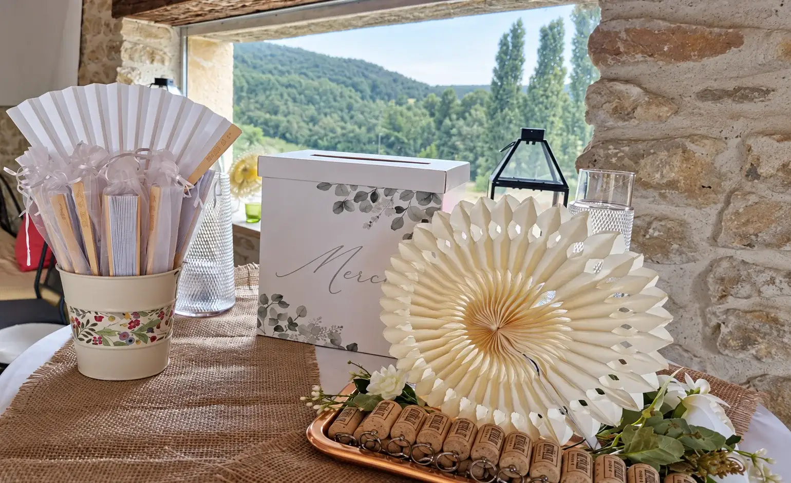 Urne, éventails et décoration de mariage devant les collines au Mas d'Eylieux
