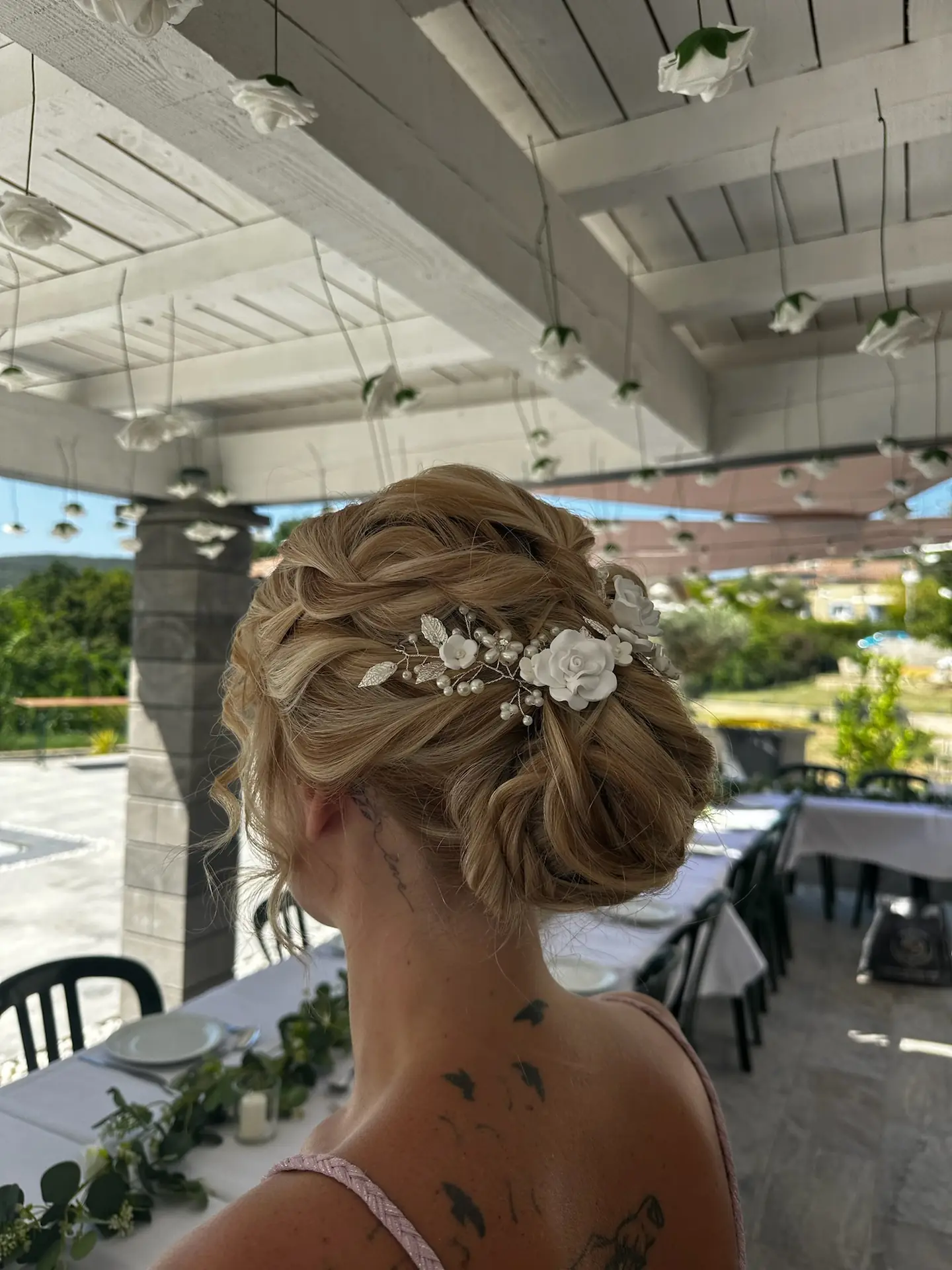 Blonder Dutt mit Drehungen und Accessoire aus weißen Blumen, eine Kreation von Pure Beauté
